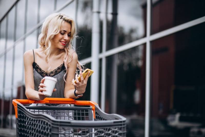 pretty-woman-with-shopping-cart-outside-phygital