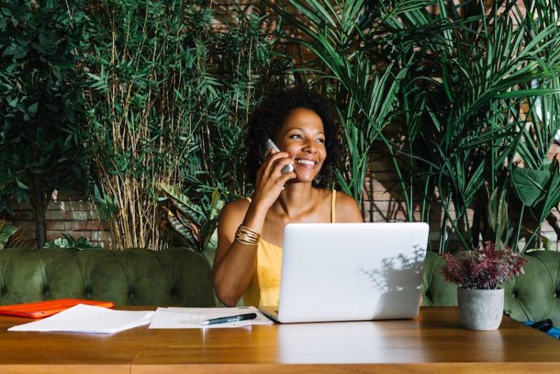 young-woman-talking-mobile-phone-smiling-greem-working