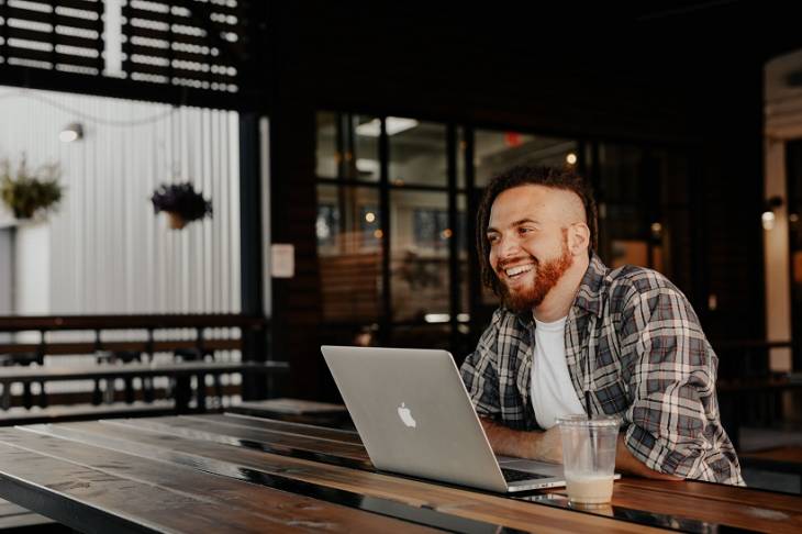 man-entrepreneur-sitted-laptop-on-table-happy-smiling