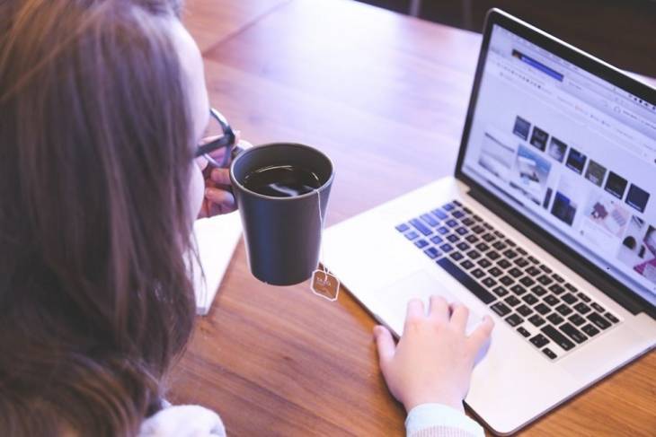 woman-with-laptop-cup-of-coffee-watching-video-web-hosting-design