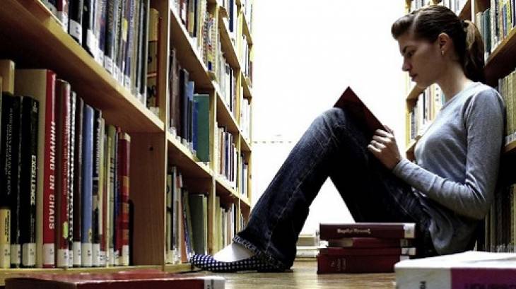 young-woman-reading-book-content-strategy-in-library