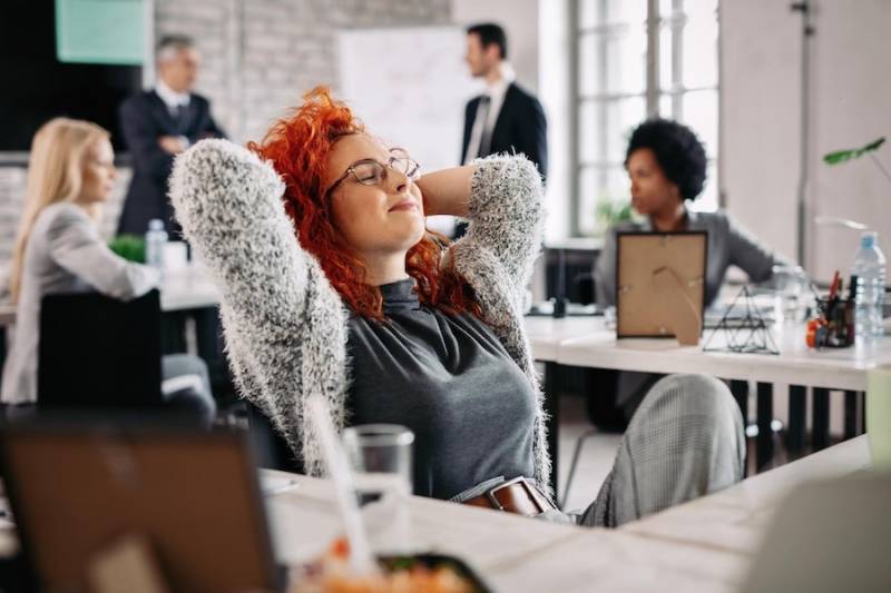 young_businesswoman_eyes_closed_office_breathe_air_quality