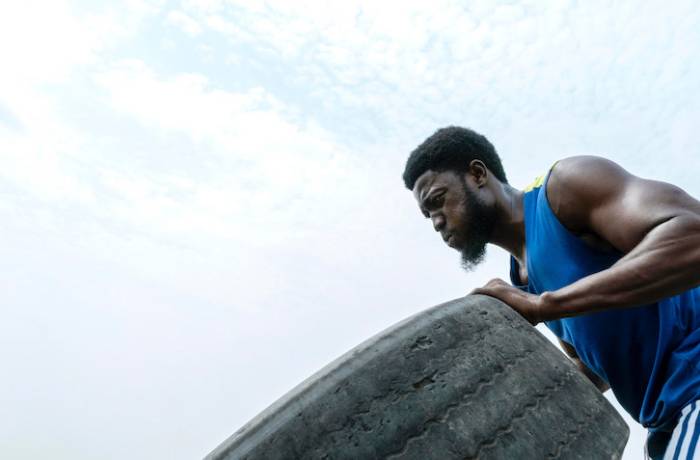 portrait-man-strong-resilient-lifting-truck-wheel