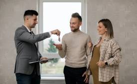 agent-handing-couple-house-keys-home-purchase