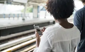 woman-train-station-using-smartphone-cheap-social-media-marketing-tactics