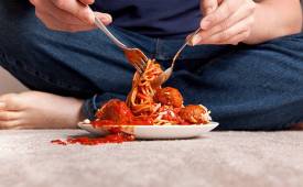 man-eating-food-on-plate-spilling-on-carpet