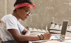 woman_sitted-desk-laptop-making_notes_internet_online_research