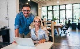 two-small-business-owners-male-female-using-laptop-smiling