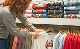 woman-choosing-t-shirt-for-sale-on-hangers