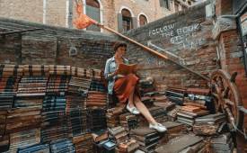 woman-reading-book-sitted-on-pile-of-books-literature-city