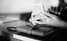 woman-using-cellphone-bible-on-table