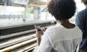 woman-train-station-using-smartphone-cheap-social-media-marketing-tactics