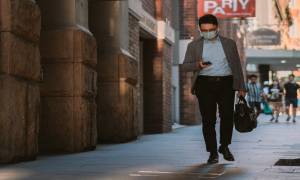 man-wearing-covid-mask-walking-street-coronavirus-unemployment