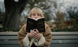 woman-sitted-on-bench-outside-reading-book