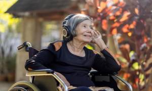 senior_woman_asian_listening_music_with_headphone_in_backyard