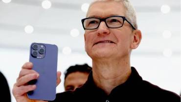 Apple CEO Tim Cook holding iPhone 15