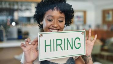 businesswoman-owner-smiling-hiring-sign