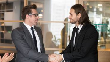smiling-businessmen-shaking-hands-making-deal-merger-and-aquisition