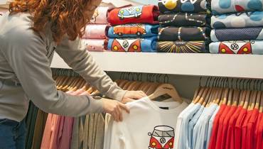 woman-choosing-t-shirt-for-sale-on-hangers