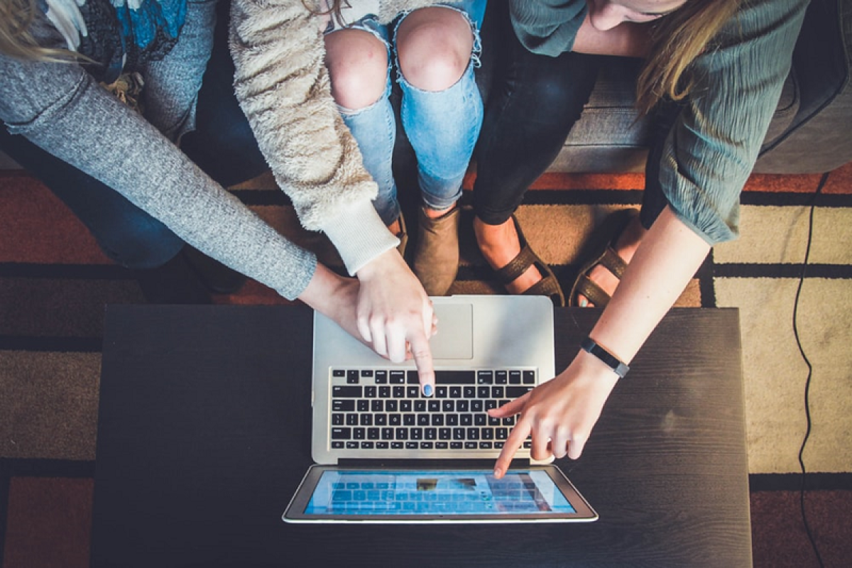 People Pointing at Laptop Screen Image for Features That Increase a Website's Engagement & Trustworthiness