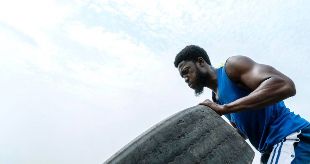 portrait-man-strong-resilient-lifting-truck-wheel