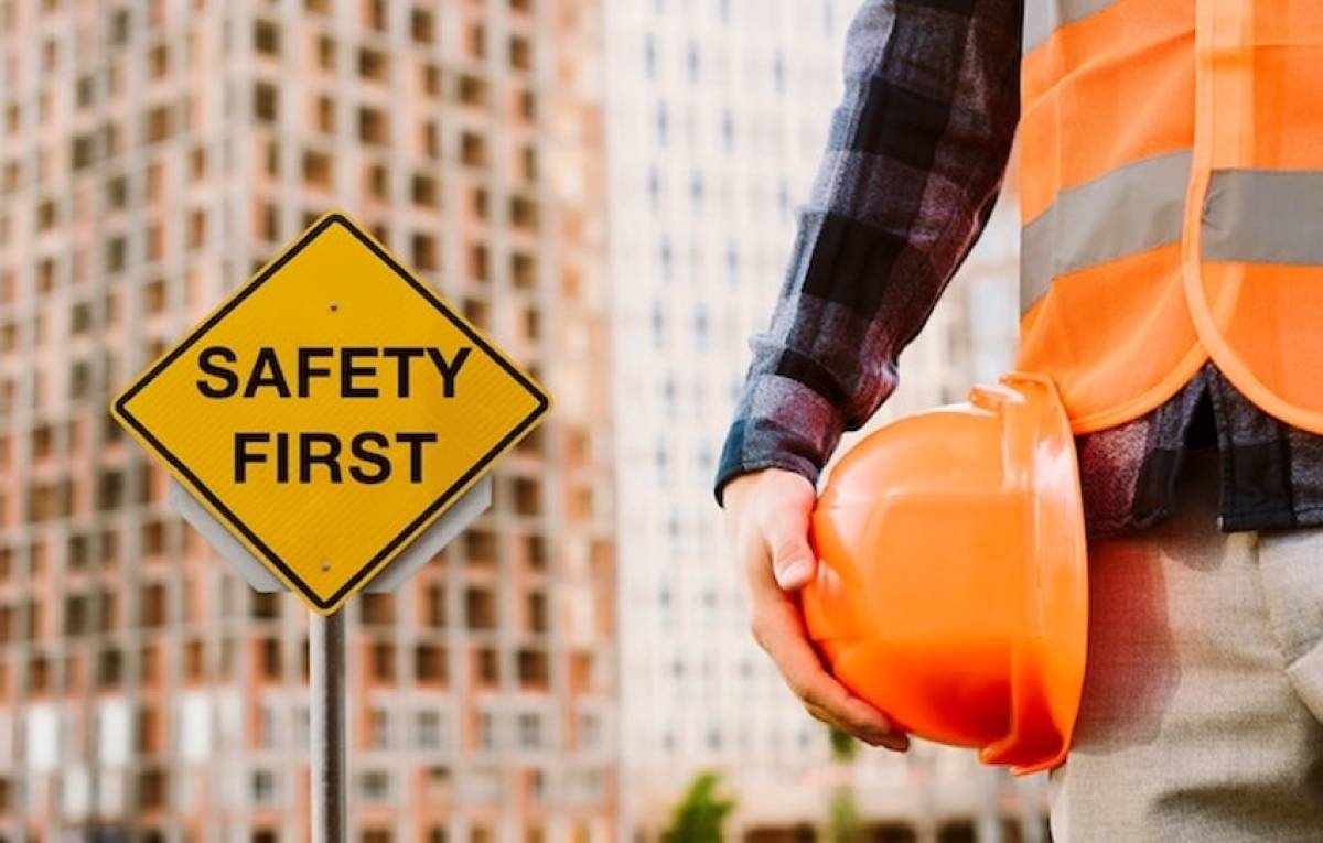 safety-first-sign-man-holding-helmet