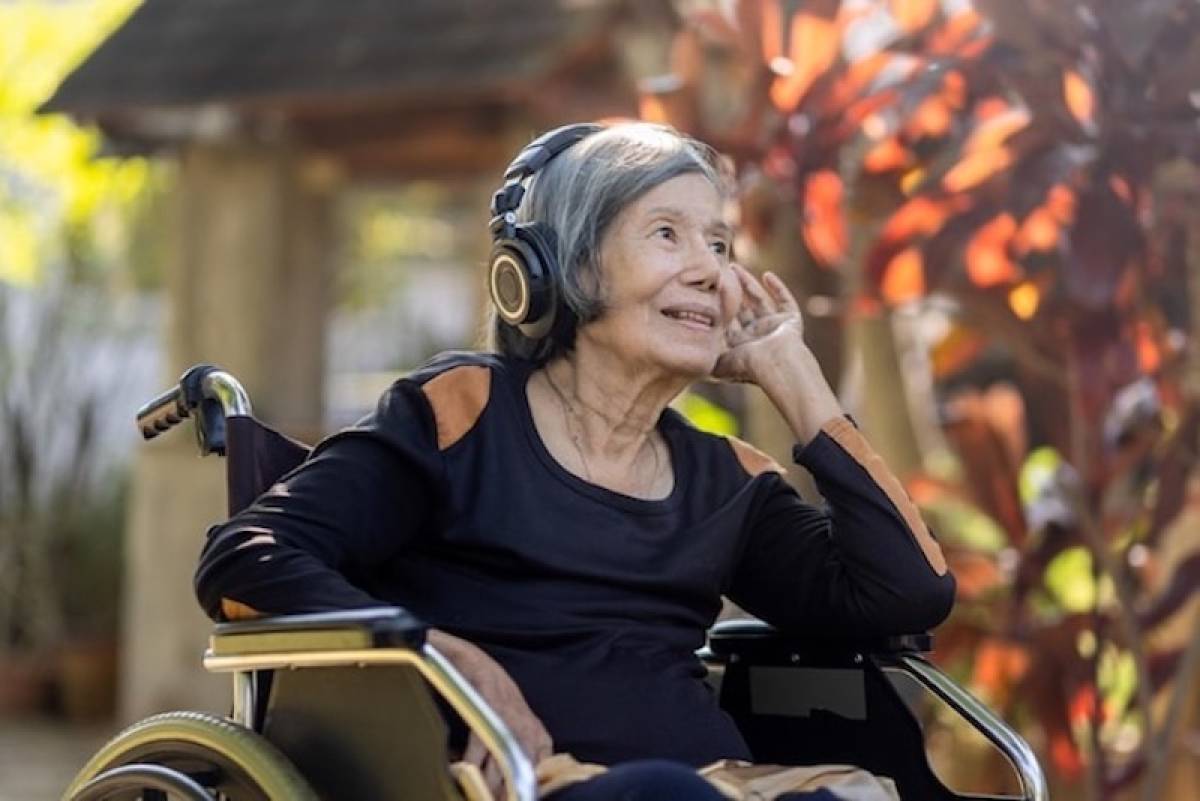 senior_woman_asian_listening_music_with_headphone_in_backyard