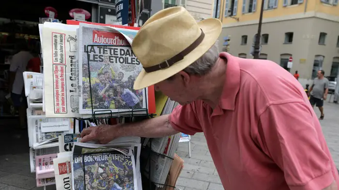 a_man_buys_a_french_daily_newspaper_in_nice_france_july_2018.jpg