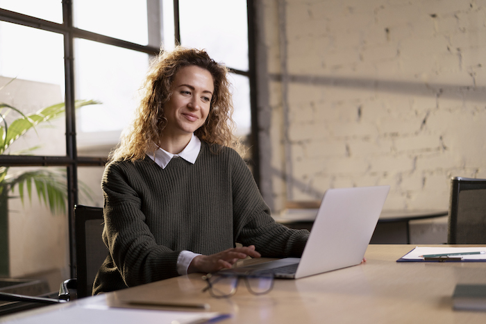 business-person-looking-at-laptop-smiling-focus-on-core-business-processes.jpg