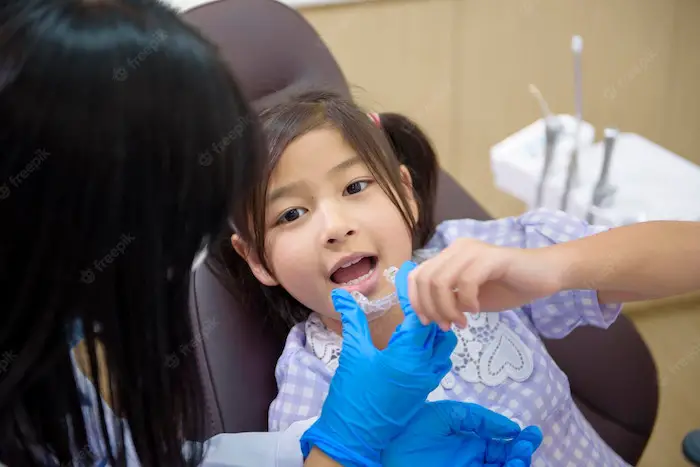 female-dentist-showing-invisalign-little-girl-dental-clinic-teeth-checkup-healthy-teeth.jpg