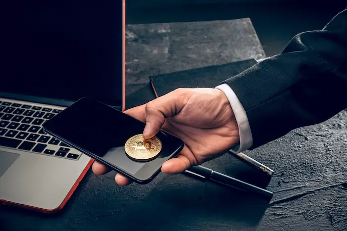 golden-bitcoin-man-hands-smartphone-laptop-crypto-wallet.jpg