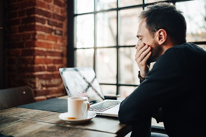 man-staring-at-laptop-screen-hand-over-mouth-fake-influencers-bad-for-business.jpg