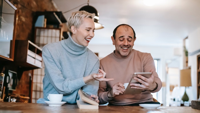 man-woman-joyful-laughing-watching-video-on-tablet-user-engagement.jpg