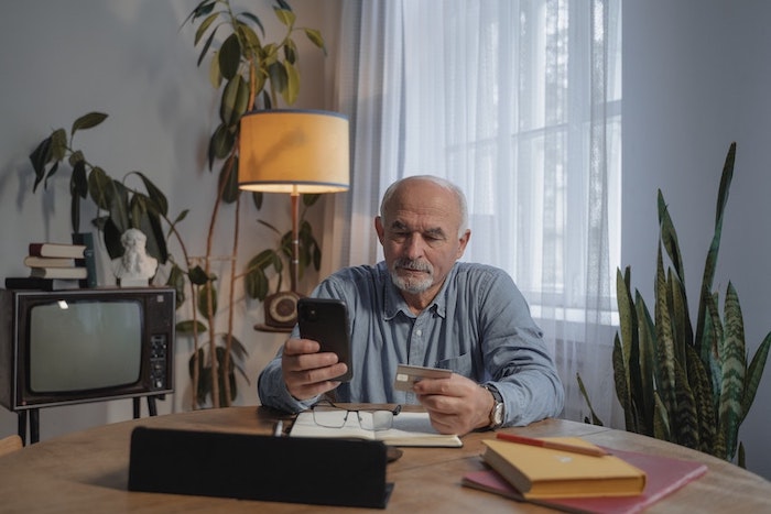 man_holding_smartphone_and_a_credit_card