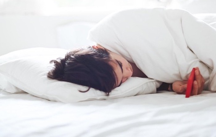 person-using-phone-in-bed