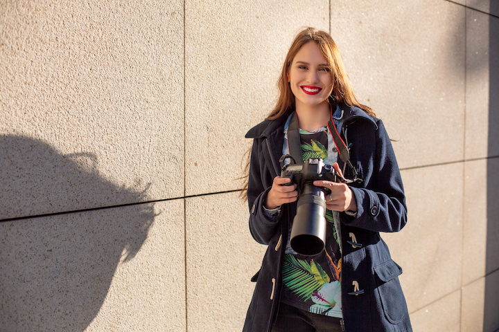 portrait_of_professional_female_photographer_on_the_street_photographing_on_a_camera