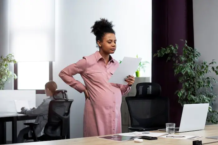 pregnant-woman-holding-paper-at-work.jpg