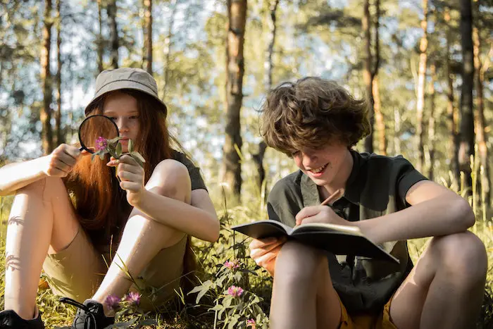teenage-girl-boy-writing-outdoors