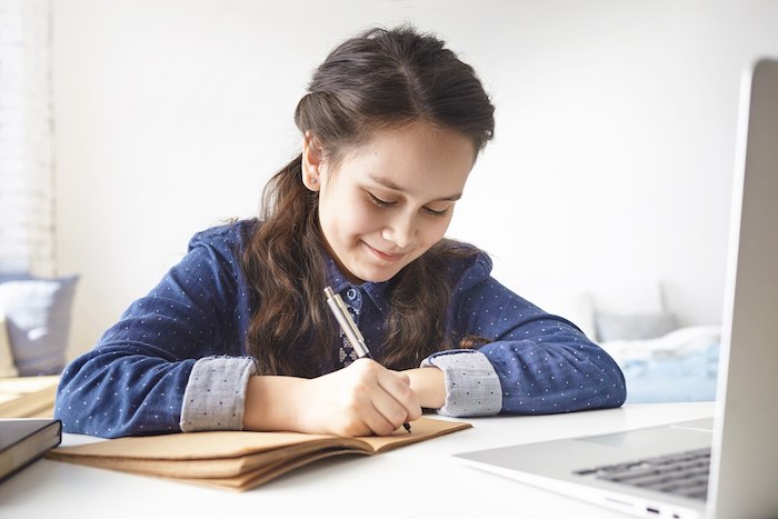 teenage-girl-sitting-desk-her-room-making-notes-writing-her-diary