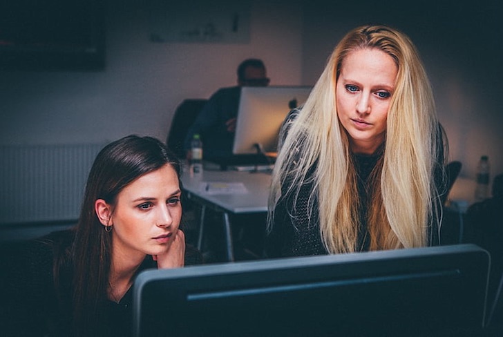 two-women-in-tech-working-on-desktop-computer