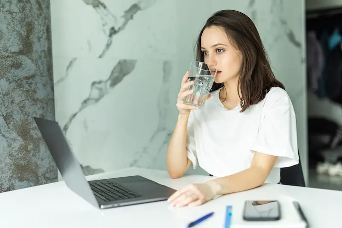 woman-drinking-water-from-glass-stay-hydrated-while-working.jpg