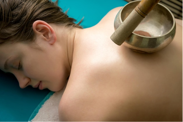 woman-lying-on-back-tibetan-singing-bowl-treatment.png