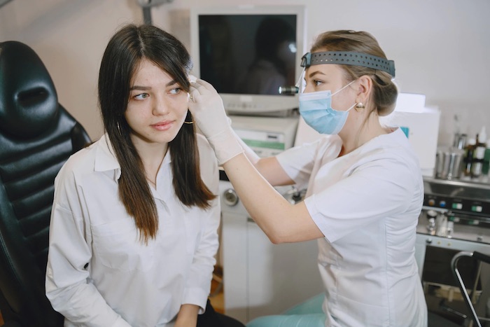 woman-patient-medical-office-doctor-medical-mask-lor-checks-woman-ears