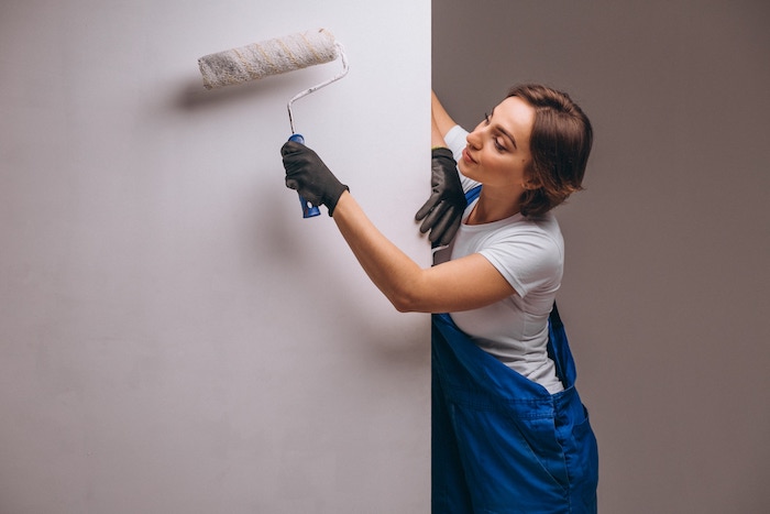 woman-with-painting-roller-painting-wall