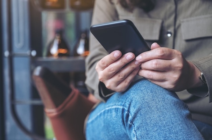 woman_holding_smartphone_using_social_media