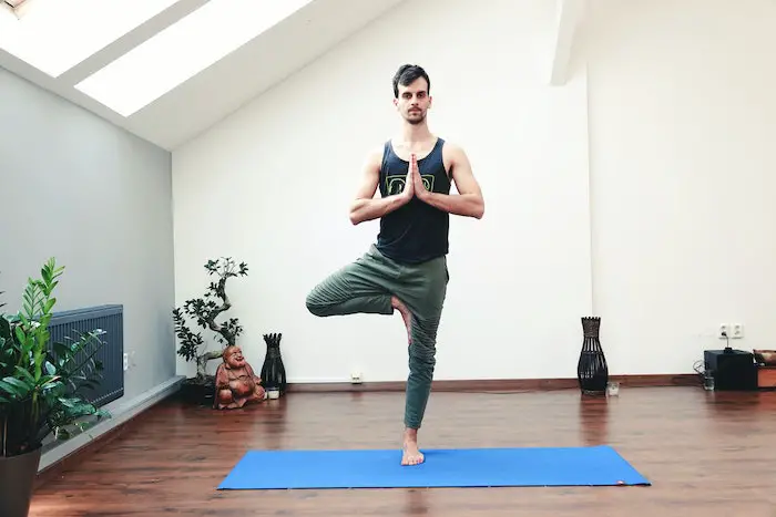 young-man-doing-yoga-tree-stand-pose