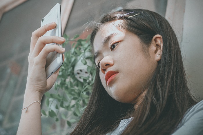 young-woman-teen-holding_smartphone_outside.jpg