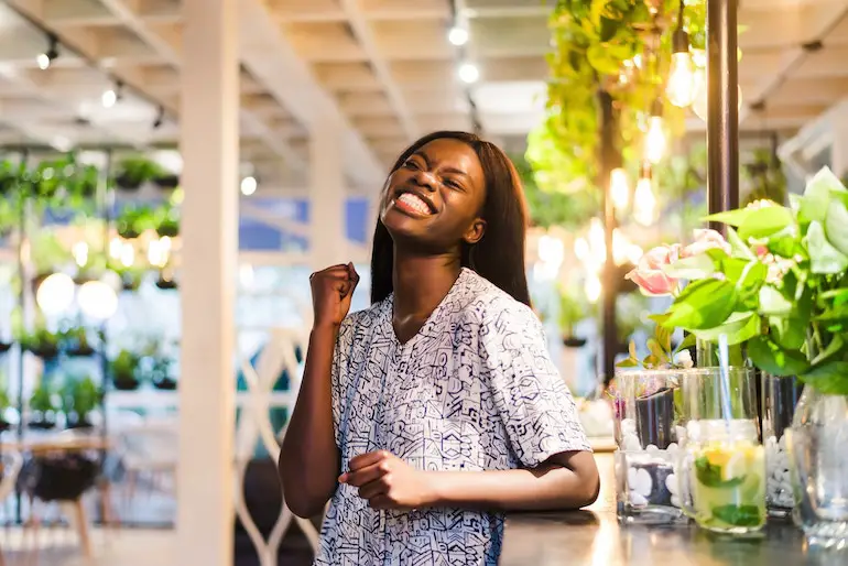 young_african_woman_standing_in_cafe_happy_successful.jpg